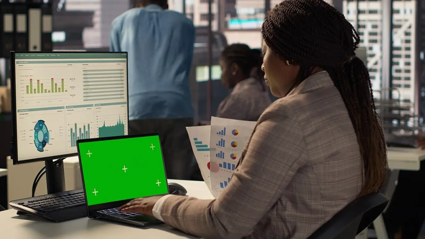 Сотрудник компании, сосредоточенный на стратегическом планировании, рядом с зелёным экраном.