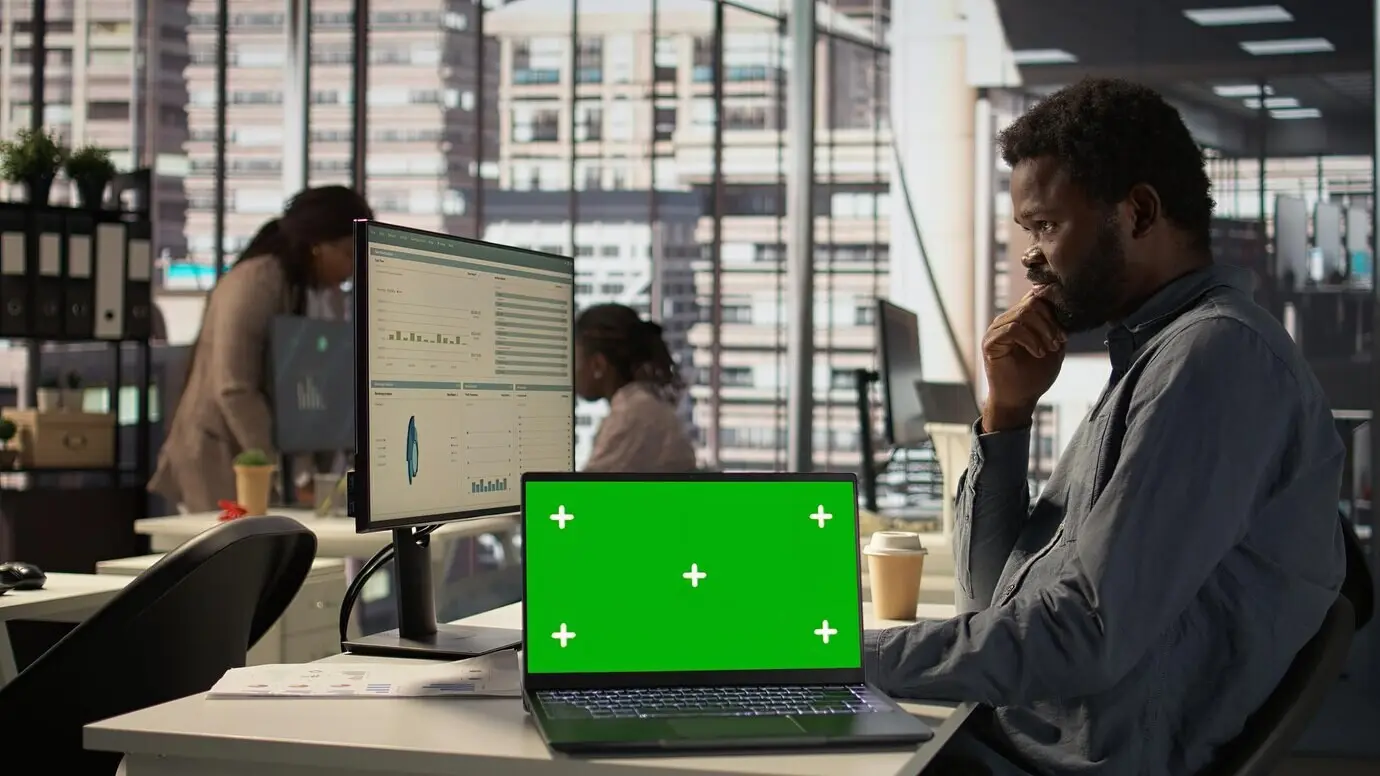 Мужчина-генеральный менеджер смотрит на макет экрана и решает задачи.